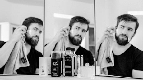 Aftershave und Gesichtscreme vor Spiegel mit Mann