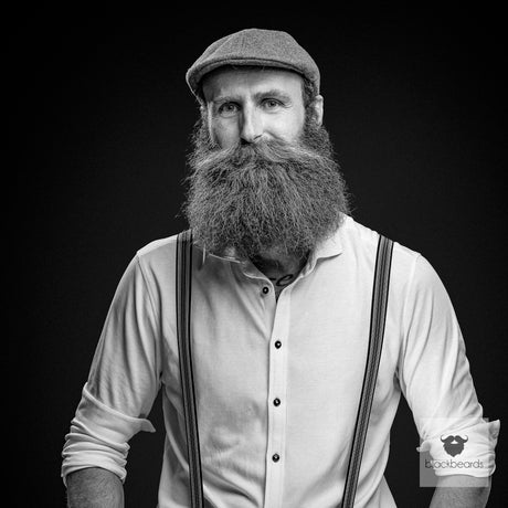 Bartträger mit Schiebermütze, Vollbart und Hosenträgern, Schwarz-Weiß-Porträt für Blackbeards