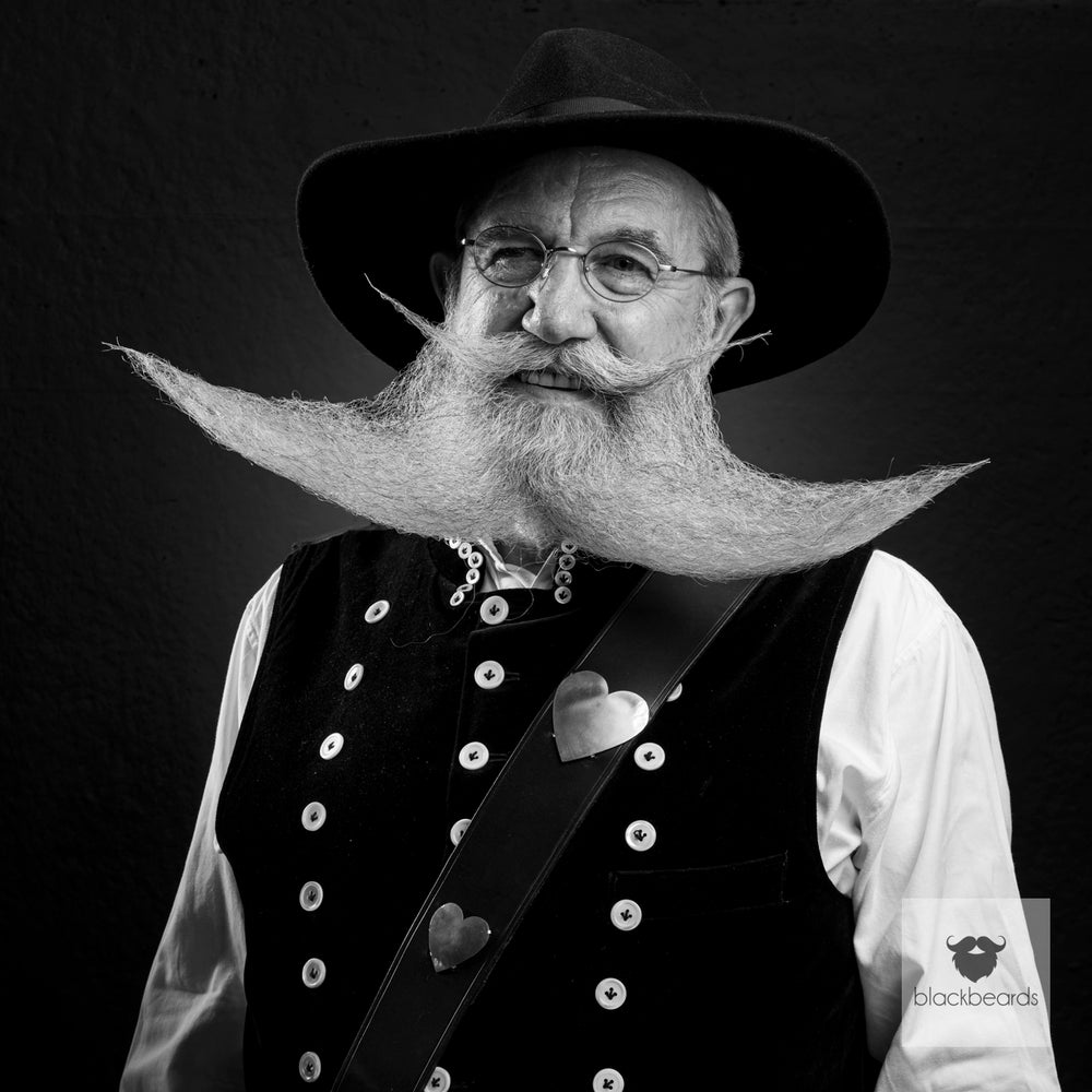Bartträger mit Hut, Brille und ausladendem weißem Bart in Tracht, Schwarz-Weiß-Porträt für Blackbeards