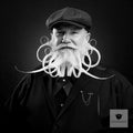 Bartträger mit Schiebermütze und weißem Freistil-Bart mit Spiralen, Schwarz-Weiß-Porträt für Blackbeards